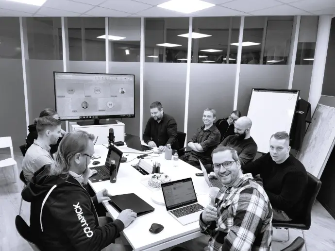 Kuva henkilöstöstä maanantain aamupalaverissa neuvotteluhuoneen pöydän ääressä